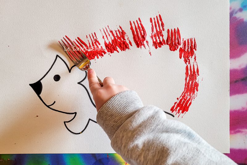 l'enfant peint les pics de l'hérisson avec une fourchette