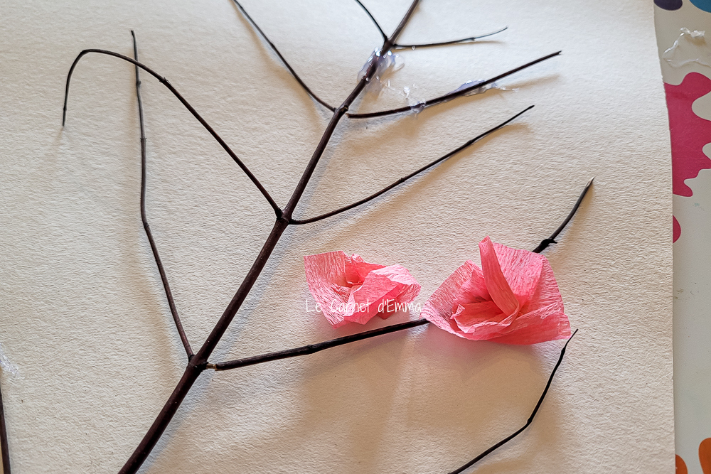 on colle les fleurs  de papier crépon sur l'arbre rose