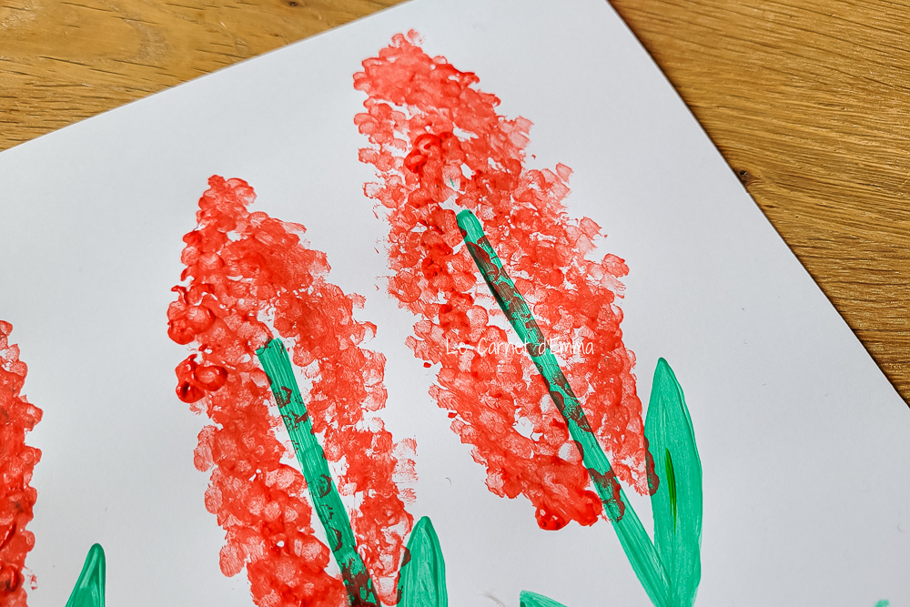 Utiliser 5 cotons tiges pour peindre les fleurs avec de la peinture rouge