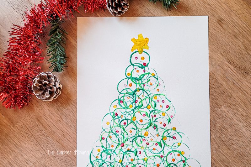 Activité manuelle sur le thème de Noël avec un sapin peint avec des rouleaux de papier toilette 