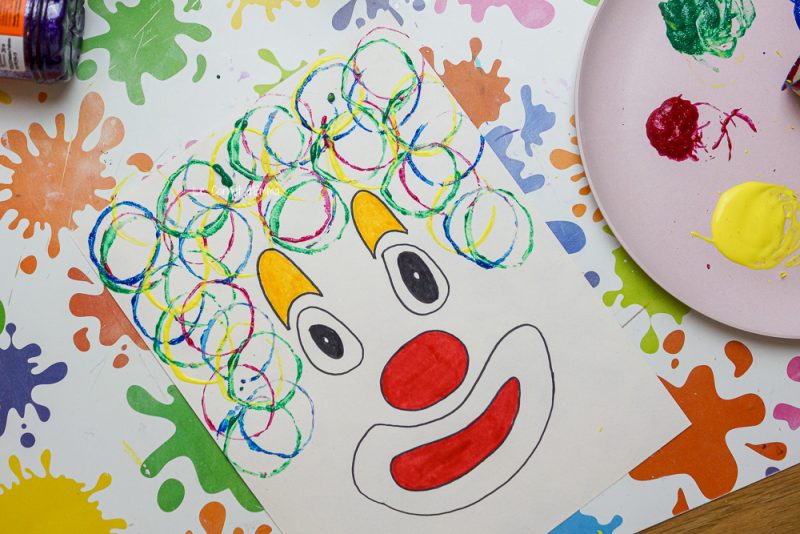 Avec un rouleau de papier toilette on peint les cheveux du clown
